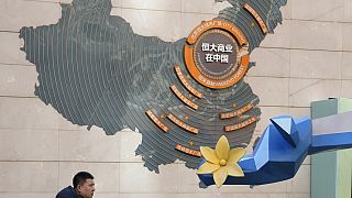 A man passes by a map depicting Evergrande's commercial projects in China at a mall in Beijing, China on Dec. 7, 2021.