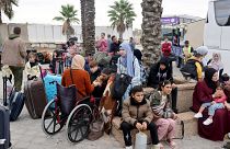 فلسطينون ينتظرون عند معبر رفح الحدودي مع مصر.