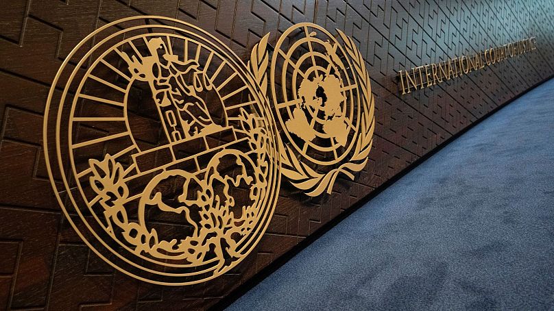 نشان دیوان بین‌المللی دادگستری (چپ) در کنار نشان سازمان ملل (راست) بر روی جایگاه قضات