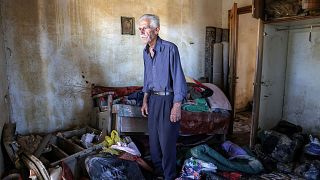 Vassilis Tsatsarelis, 80, stands among debris at his damaged house, in the aftermath of Storm Daniel, in the village of Metamorfosi, Greece, 13 November 2023.