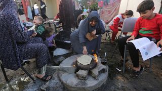 أم فلسطينية لاجئة تعد الخبز في رفح