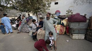 أفغان ينتظرون وصول وسائل النقل إلى وطنهم في كراتشي