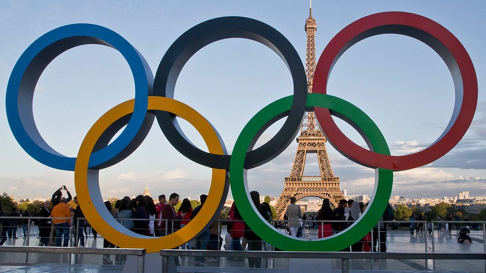 Изображение показва олимпийските кръгове с Айфеловата кула на заден план.