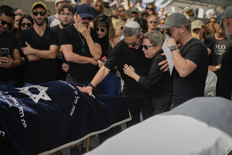 Mourners gather in grief around the bodies of Danielle Waldmann and her partner Noam Shai during their funeral in the northern Israeli town of Kiryat Tivon 12 Oct. 2023.