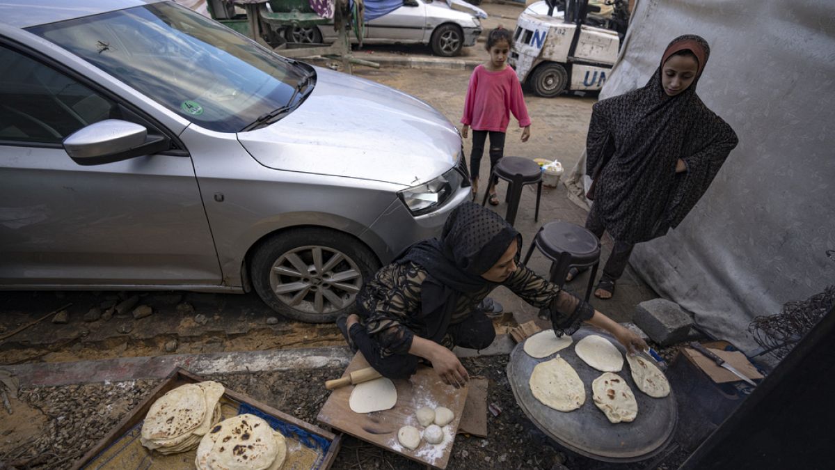 Εκτοπισμένοι Παλαιστίνιοι ετοιμάζουν ψωμί σε ανοιχτό χώρο στη Γάζα