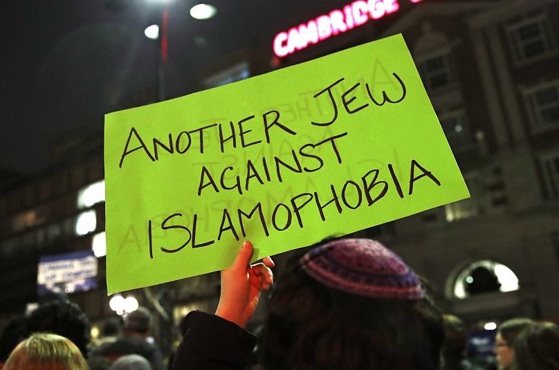 لافتة مرفوعة مكتوب عليها: "يهودي آخر ضد الإسلاموفوبيا" أثناء احتجاج لمئات من الأشخاص نظمته جمعية هارفارد الإسلامية بالقرب من حرم جامعة هارفارد
