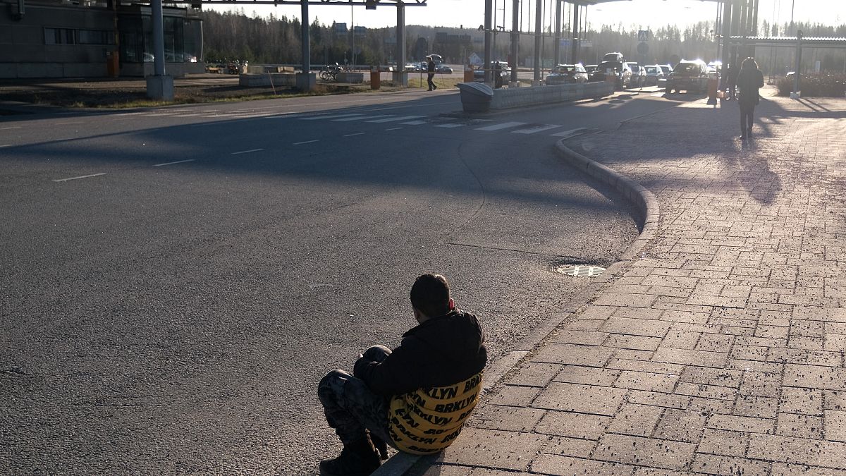 Egy menedékkérő ül a földön a Finnország és Oroszország közötti Nuijamaa határátkelőnél.