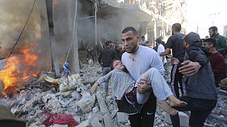 Des Palestiniens  viennent au secours de survivants d'une attaque israélienne sur Rafah, dans la bande de Gaza (17 novembre 2023)