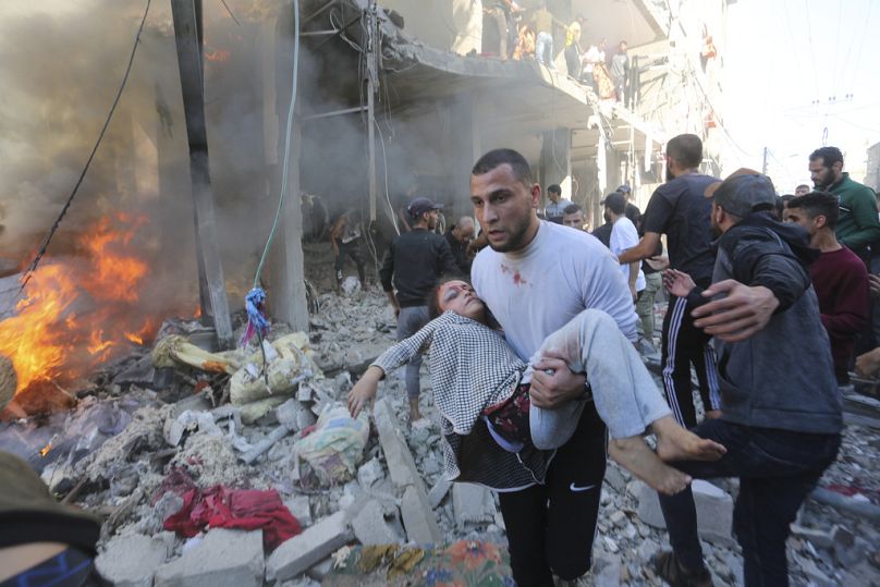 FILE - Palestinians rescue survivors after an Israeli strike on Rafah, Gaza Strip, Friday, Nov. 17, 2023.