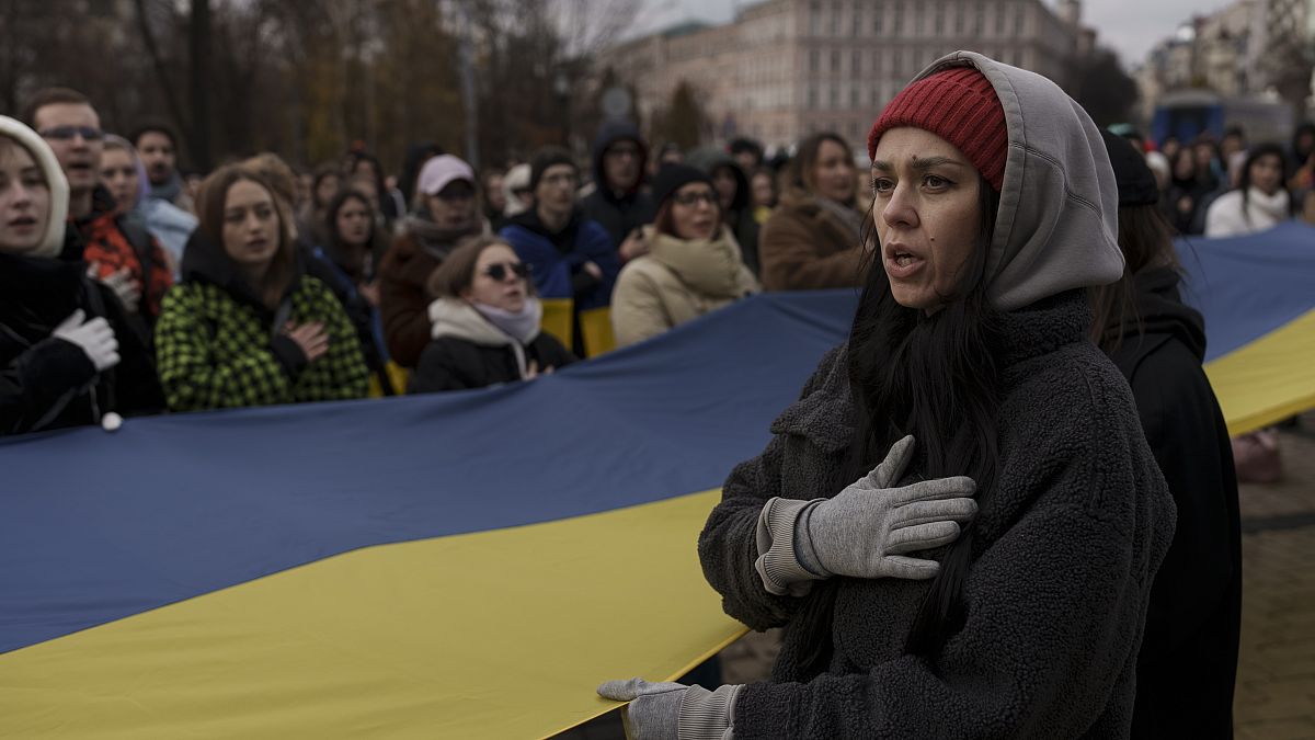 A woman sings the Ukraine national anthem during a demonstration in Kyiv on Saturday, as people gathered to demand the reallocation of public funds to the Armed Forces