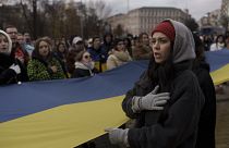 A woman sings the Ukraine national anthem during a demonstration in Kyiv on Saturday, as people gathered to demand the reallocation of public funds to the Armed Forces
