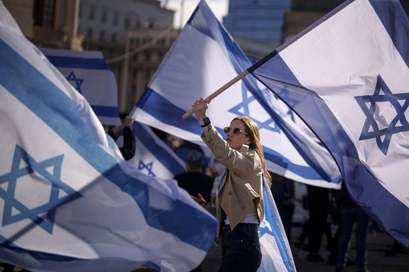 FILE - A woman holds an Israeli flag during a rally in solidarity with Israel and those held hostage by Hamas in Gaza in Bucharest, Romania on Nov. 12, 2023.