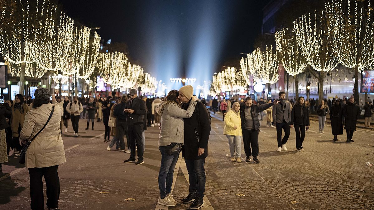Ζευγάρι παρακολουθεί τα εγκαίνια της τελετής φωταγώγησης της λεωφόρου Champs Elysee για την περίοδο των Χριστουγέννων, στο Παρίσι, Κυριακή, 19 Νοεμβρίου 2023