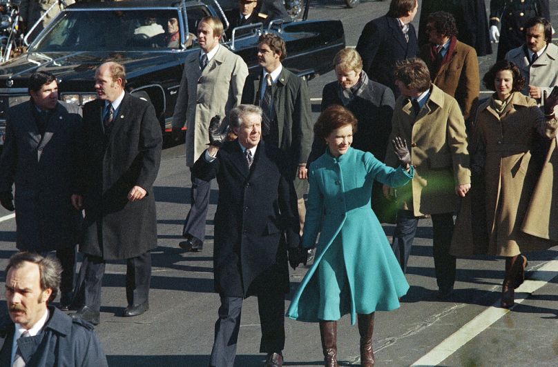 جيمي كارتر والسيدة الأولى روزالين كارتر يسيران في شارع بنسلفانيا بعد أن أدى كارتر اليمين بصفته الرئيس التاسع والثلاثين للدولة، في 20 يناير 1977، واشنطن العاصمة