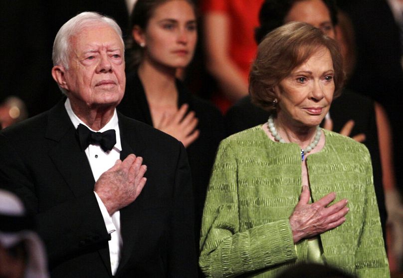 الرئيس الأسبق جيمي كارتر وزوجته روزالين يقفان لعزف النشيد الوطني في مركز كينيدي، 21 مارس 2011،