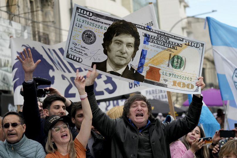 Javier Milei, holds up a giant cardboard depicting a U.S. 100 banknote emblazoned with an image of his face, during a rally in La Plata, Argentina, Tuesday, Sept. 12, 2023