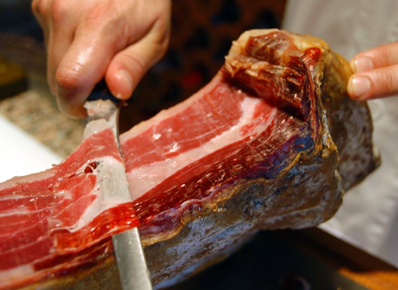 A man cuts a Manuel Maldonado's Iberian ham in Alburquerque, August 2007