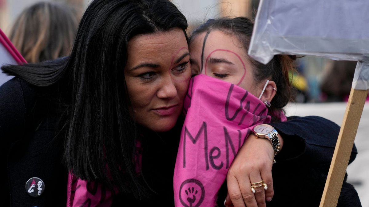 Demonstrators hug each other during a protest against violence on women, in Rome, Saturday, Nov. 27, 2021. 