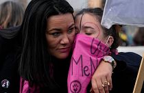 Demonstrators hug each other during a protest against violence on women, in Rome, Saturday, Nov. 27, 2021. 