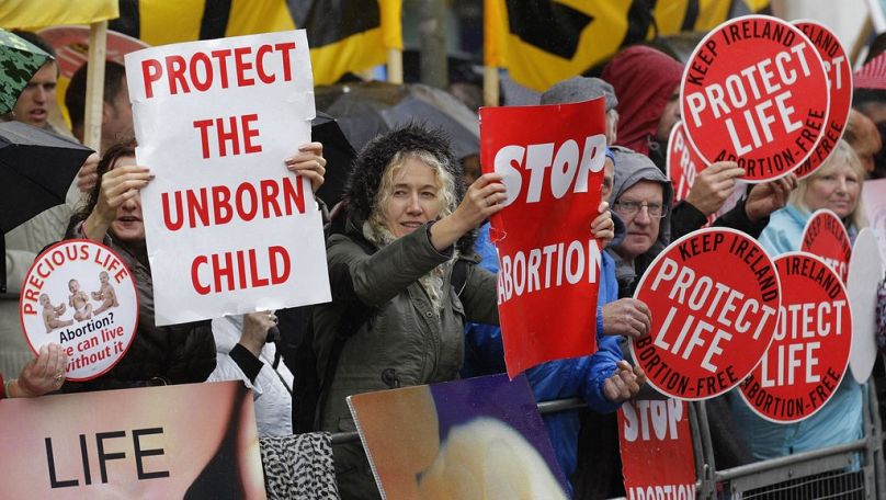 FILE - In this Thursday, Oct. 18, 2012 file photo, protesters opposed to abortion hold placards outside the Marie Stopes clinic in Belfast, Northern Ireland.