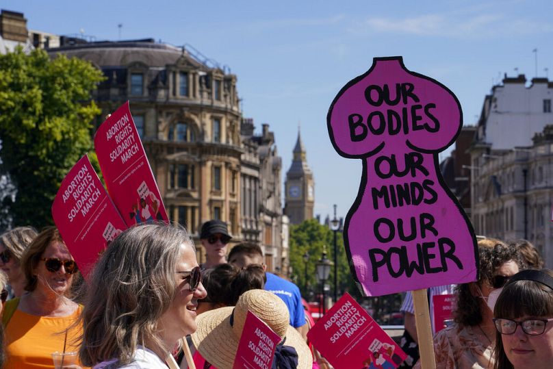 Demonstrators hold placards as they attend a march in support of the Abortion Rights group, in London, Saturday, July 9, 2022.