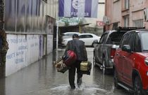 عامل يعود إلى منزله في شارع غمرته المياه في وسط مدينة أنقرة