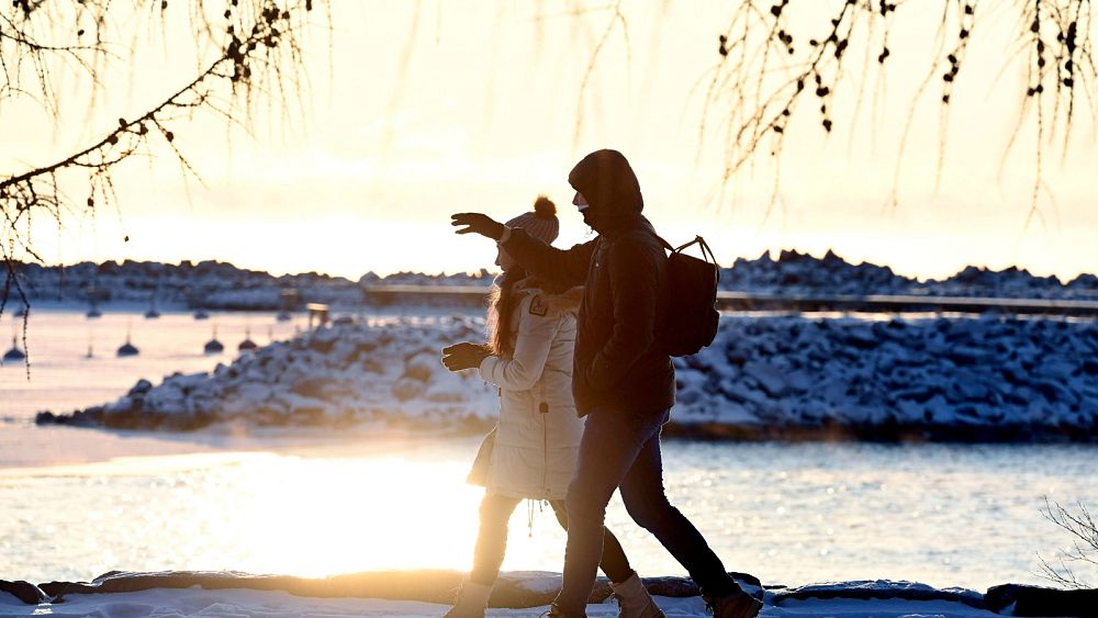 ФАЙЛ Двойка се разхожда край морето в слънчев но мразовит