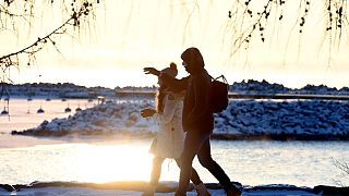 FILE: A couple walk by the seaside on a sunny but frosty day in Espoo, Finland, December 2021