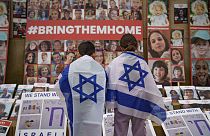 FILE - Children look at photographs of Israelis kidnapped by Hamas during a rally joined by hundreds in solidarity with Israel in Romania, 2023. 