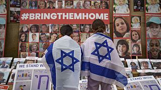 FILE - Children look at photographs of Israelis kidnapped by Hamas during a rally joined by hundreds in solidarity with Israel in Romania, 2023. 