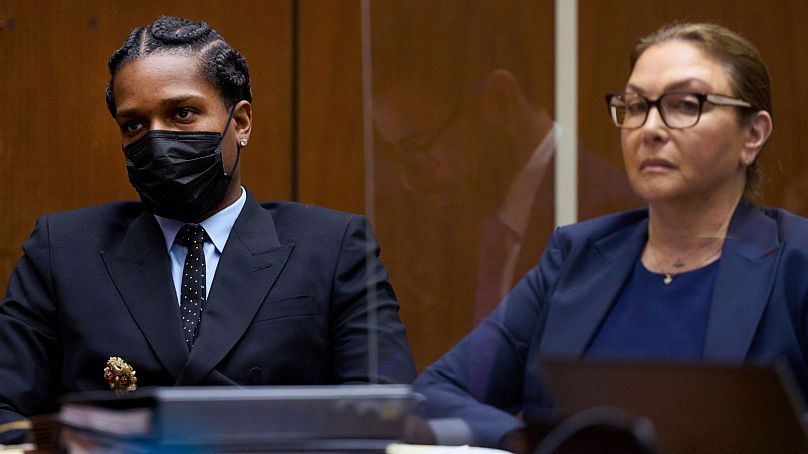 A$AP Rocky, sits with a member of his legal team