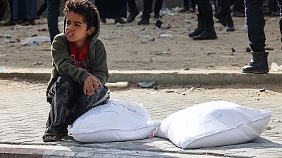 طفل فلسطيني بالقرب من أكياس الطحين رفح قطاع غزة