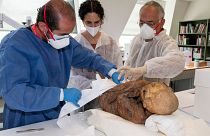 Archaeologists prepare one of three pre-Columbian mummies for transport to Bolivia.