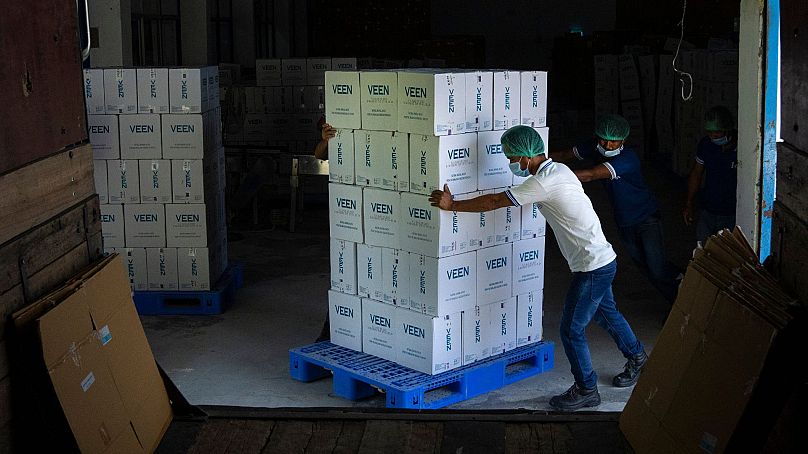 Workers push a trolley loaded with cartons of Veen mineral water before loading it into a truck inside a bottling plant near Samtse, Bhutan, Wednesday, 10 May, 2023.