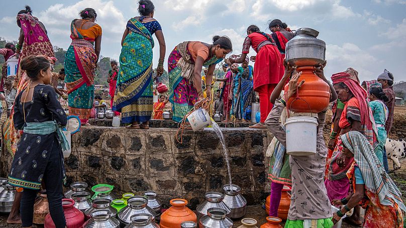 Women gather around a well to draw water in the village of Telamwadi, northeast of Mumbai, India. Tankers bring water from a local river after it's been treated with chlorine