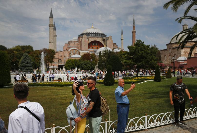 Turistler İstanbul'daki Ayasofya Camisini arka plana alarak fotoğraf çekiyor