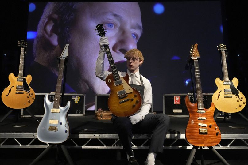 A Christie's employee shows a Gibson Kalamazoo guitar among others owned by Dire Straits singer, songwriter and guitar hero Mark Knopfler,