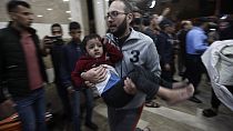 A wounded Palestinian child is carried into the Nasser Hospital following an Israeli bombardment on Khan Younis refugee camp, southern Gaza Strip, Tuesday, Nov. 21, 2023.