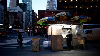 بائع متجول يقف بجوار عربته في شارع ليكسينغتون في وسط مانهاتن في 13 نوفمبر 2019 في مدينة نيويورك.