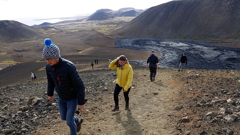 Menschen wandern, um einen Blick auf die Eruptionen des Vulkans Fagradalsfjall in Island am 3. August 2022 zu erhaschen.