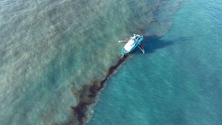 In this photo provided by the US Coast Guard, a Clean Gulf Associates response vessel skims crude oil off the coast of Louisiana.