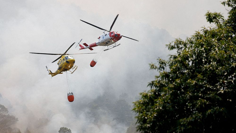 Противопожарни хеликоптери летят над Агуаманса докато горските пожари бушуват извън