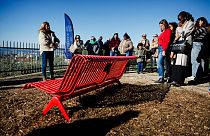 Participants hold a minute of silence for victims of feminicides during the inauguration of a red bench in the "Font Obscure" parc in the northern part of Marseille