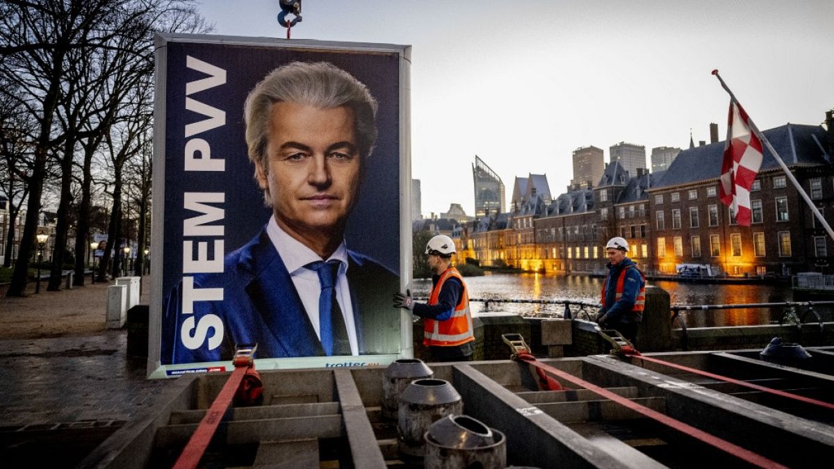 Workers prepare to remove an election sign of Party for Freedom (PVV) leader Geert Wilders near the Binnenhof, a day after the Netherlands general elections