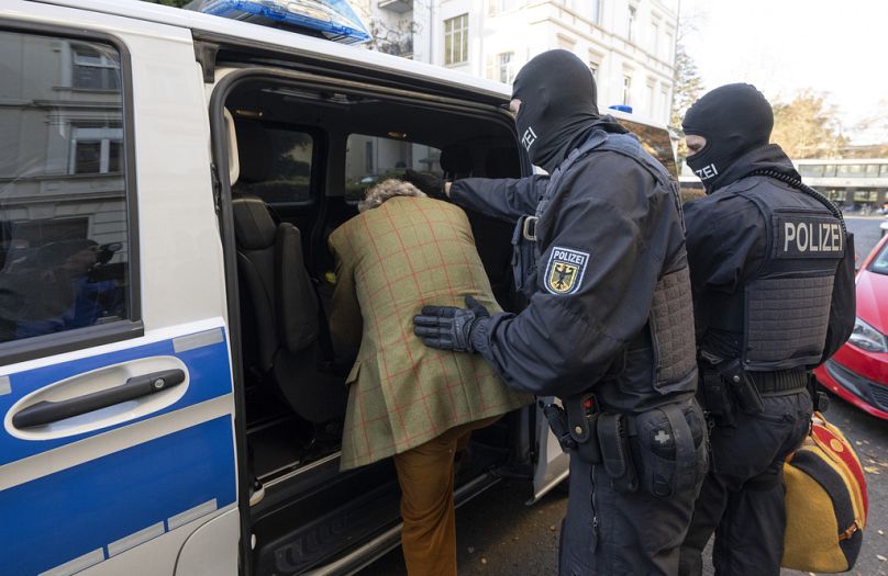 Police officers bundle Heinrich XIII Prince Reuss into a police vehicle during a raid against the Reichsbürger movement in December 2022.