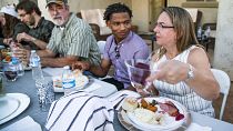 Jamal Hinton, centre, Wanda Dench, right, and her family and friends, have Thanksgiving dinner at Dench's home on 24 November 2016, in Mesa, Arizona.
