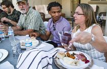 Jamal Hinton, centre, Wanda Dench, right, and her family and friends, have Thanksgiving dinner at Dench's home on 24 November 2016, in Mesa, Arizona.
