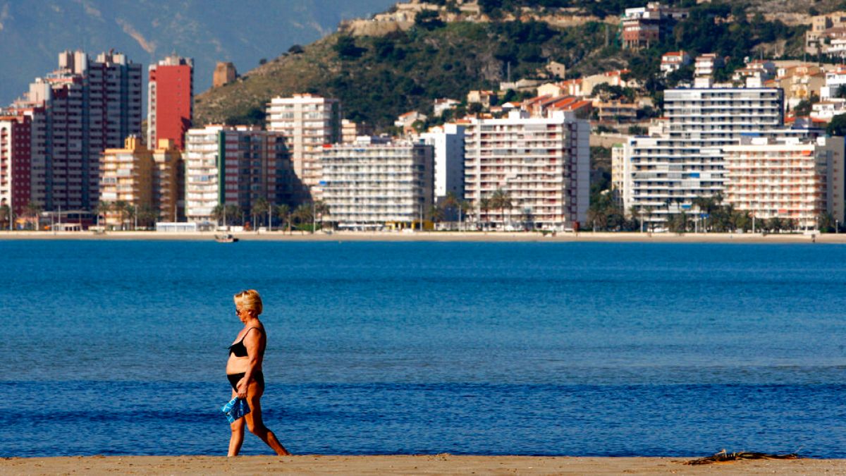 A woman walks on the beach of the Village of Cullera,south of Valencia, Spain, on Thursday, April 3, 2008. 