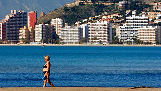 A woman walks on the beach of the Village of Cullera,south of Valencia, Spain, on Thursday, April 3, 2008. 