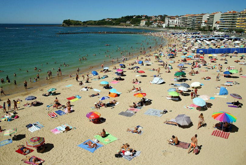 Menschen liegen am 5. August 2020 am Strand von Saint Jean de Luz im Südwesten Frankreichs.